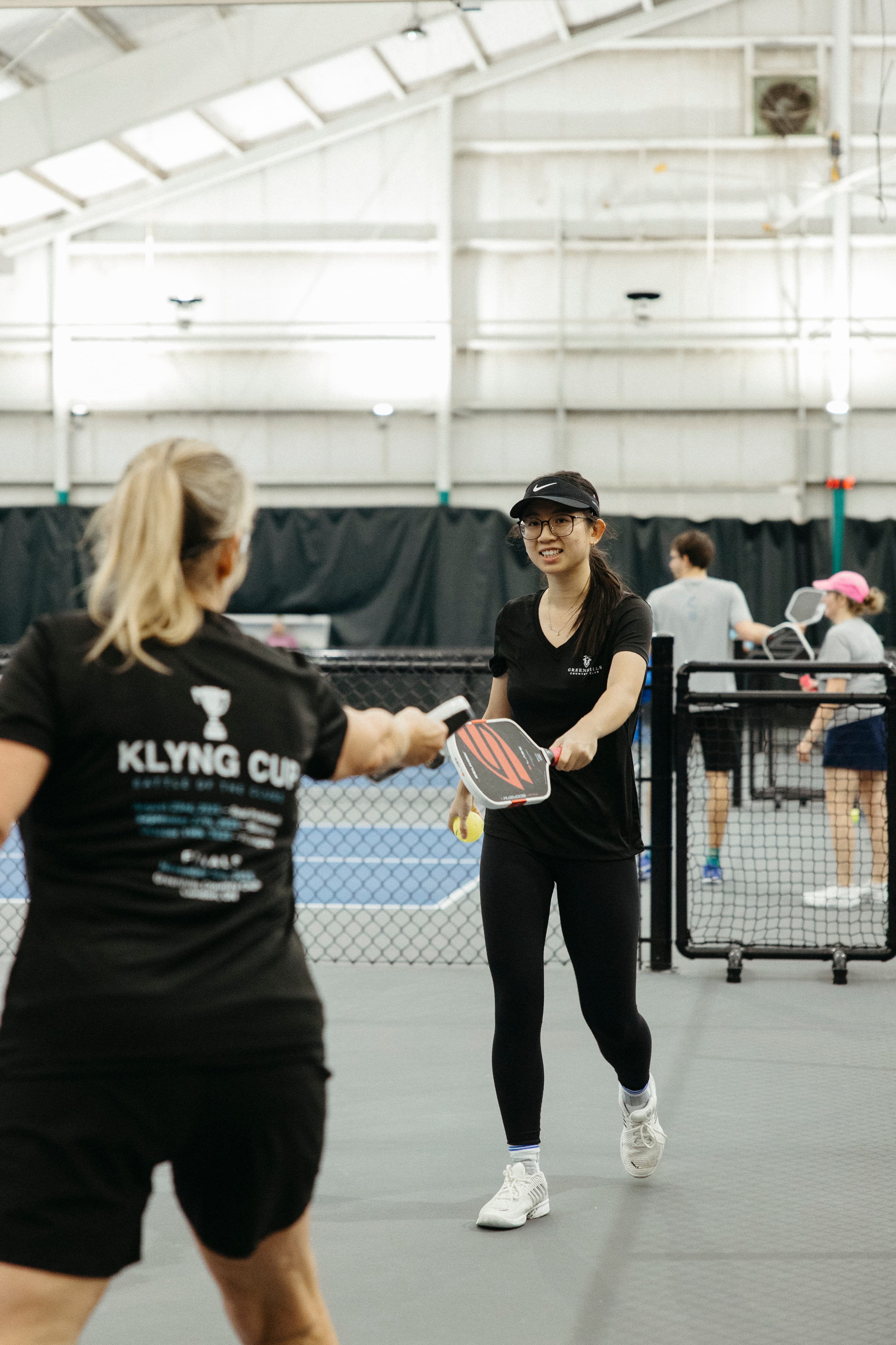 Players paddle-tapping at the net after a competitive pickleball match